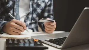 persoon achter laptop met creditcard in de hand